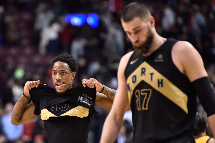 Toronto Raptors guard DeMar DeRoza , left, and center Jonas Valanciunas (17) walk off the court following the team's 97-93 loss to the Utah Jazz in an NBA basketball game Friday, Jan. 26, 2018, in Toronto. (Frank Gunn/The Canadian Press via AP)
