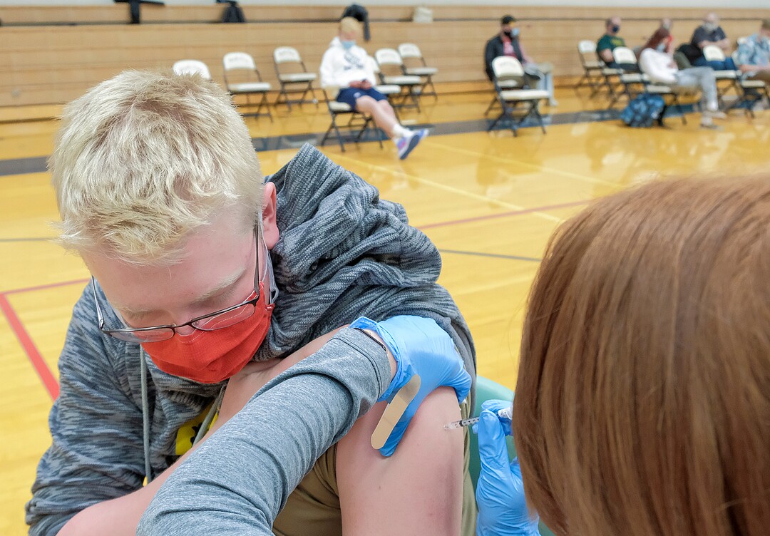 (Leah Hogsten | The Salt Lake Tribune) Badger Norman, 17, a student at Woods Cross High School receives his first Pfizer vaccine at a pop-up clinic by Nomi Health,  April 27, 2021. County and regional health districts are setting up vaccination clinics in high schools, to get the COVID-19 vaccine to 16 and 17-year-olds.