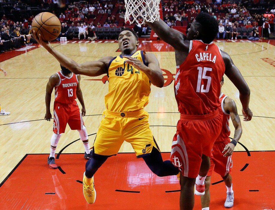 Utah Jazz guard Donovan Mitchell (45) drives to the basket against Houston Rockets center Clint Capela (15) during the first half of an NBA basketball game, Monday, Dec. 18, 2017, in Houston. (AP Photo/Eric Christian Smith)