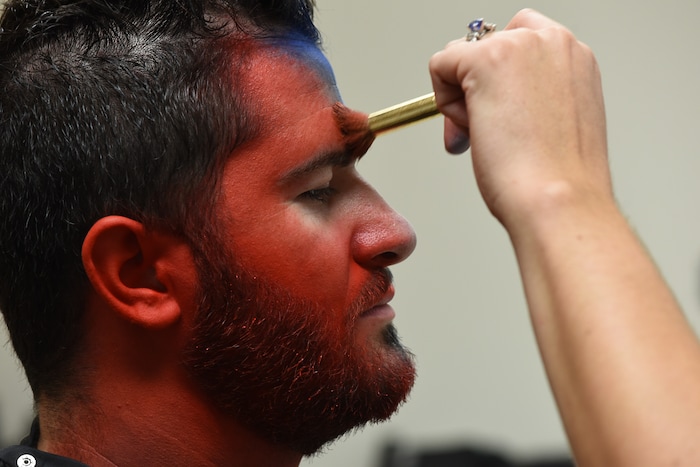 (Francisco Kjolseth | The Salt Lake Tribune) Makeup artist Kristen Packard works her magic on Brad Klekas of South Jordan, a BYU and Utah fan alike as he's willing to show his mutual admiration of both teams by stepping into the Tribune studio to get both colors in anticipation of the upcoming match up between the two rival teams on Saturday.
