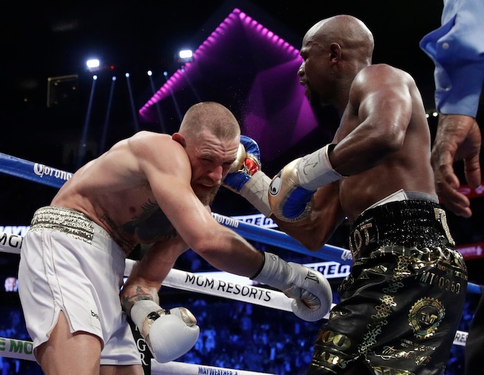 Floyd Mayweather Jr. hits Conor McGregor in a super welterweight boxing match Saturday, Aug. 26, 2017, in Las Vegas. (AP Photo/Isaac Brekken)