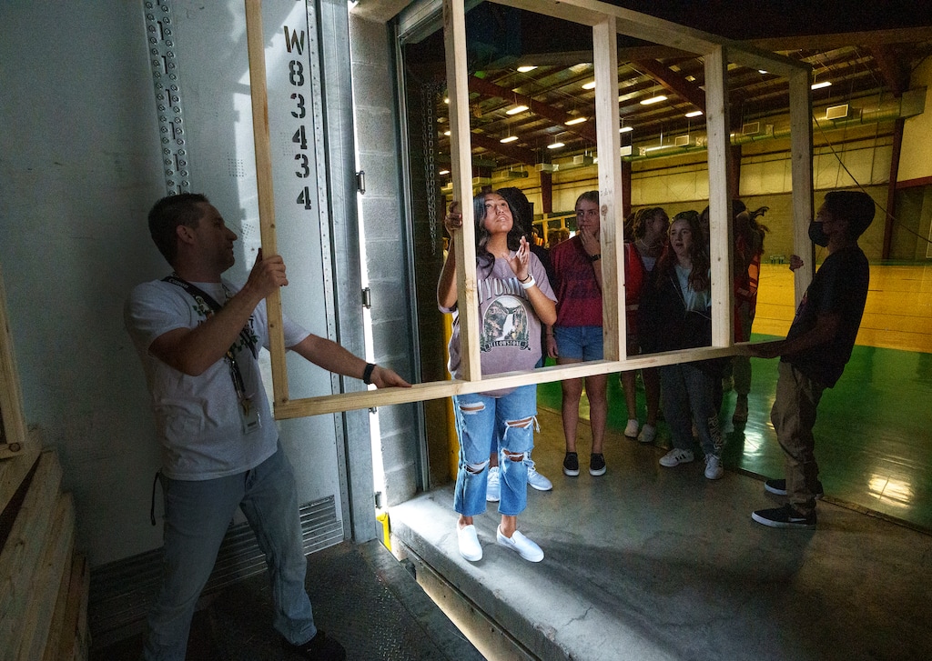 (Leah Hogsten | The Salt Lake Tribune) Wahlquist Junior High students Evelyn Lopez, center, and Marcos Salas, right, carry wood frames for the exhibits for Weber Remembers 9/11, Sept. 7, 2021. The free event will be held Sept. 9-11 at the Weber County Fairgrounds. It includes an interactive museum, over 300 photographs, military members, first responders, local police and fire departments, food trucks and activities for kids.