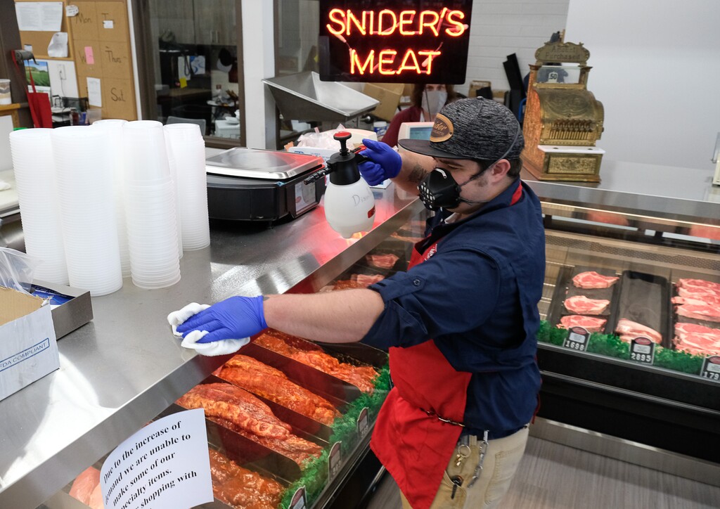 (Francisco Kjolseth  |  The Salt Lake Tribune) General Manager Jake Wilson does a regular surface cleaning as a steady stream of customers visits Snider Bros. Meats in Cottonwood Heights on Tuesday, May 5, 2020, where owners Will and Amy Wilson have been requiring that all customers wear masks or facial coverings when they come to shop. They say it's important to protect their employees, several of whom are the sole breadwinners in their families and have at-risk family members.