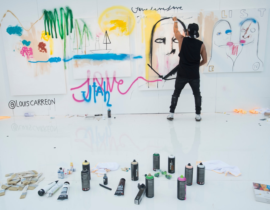 (Rick Egan  |  The Salt Lake Tribune)  Los Angeles artist Louis Carreon, works on four canvases that will be auctioned off later in the evening at the LoveLoud Festival at Brent Brown Ballpark at UVU campus, Saturday, August 26, 2017.