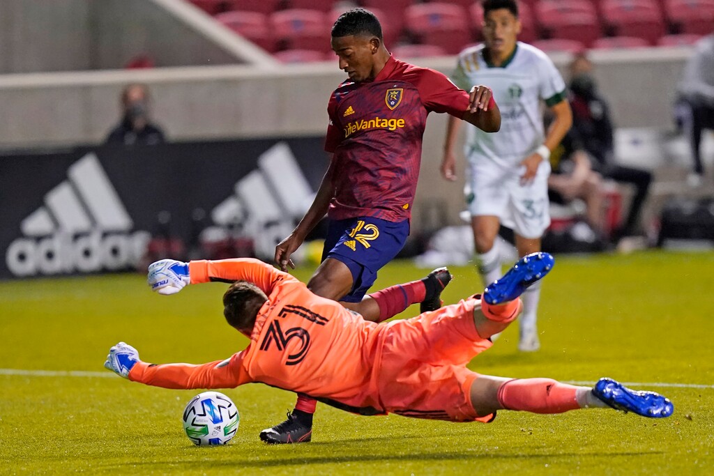 (Rick Bowmer | The Associated Press) Real Salt Lake forward Douglas Martinez (12) scores against Portland Timbers goalkeeper Aljaz Ivacic (31) in the first half of an MLS soccer match Wednesday, Oct. 14, 2020, in Sandy, Utah.