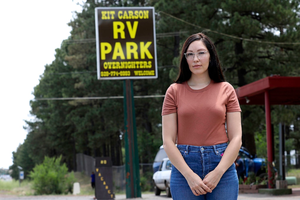 (Rachel Gibbons | Arizona Daily Sun via AP) Adriana Orman stands outside the 102-year-old Kit Carson RV Park in Flagstaff , Ariz.,on Friday, July 10, 2020. Orman helped start a petition to change the name of the RV park named for the explorer, which is gaining momentum in the wake of public conversations on systemic racism and white supremacy.