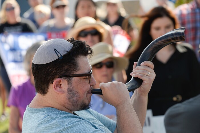 (Francisco Kjolseth  |  The Salt Lake Tribune)  Jewish community member Benjamin Luks-Morgan blows on a ram horn known as the shofar as a way to "blast into our consciousness the possibility of redemption, of an end to the dehumanizing and targeting of immigrants, of a world in which all people find sanctuary, safety and home." Utah Jewish Community organizations, their members and friends gathered outside of the U.S. Immigration and Customs Enforcement (ICE) field office at 2975 S. Decker Lake Drive, West Valley City, on Saturday, Aug. 10, 2019, for a Close The Camps vigil.