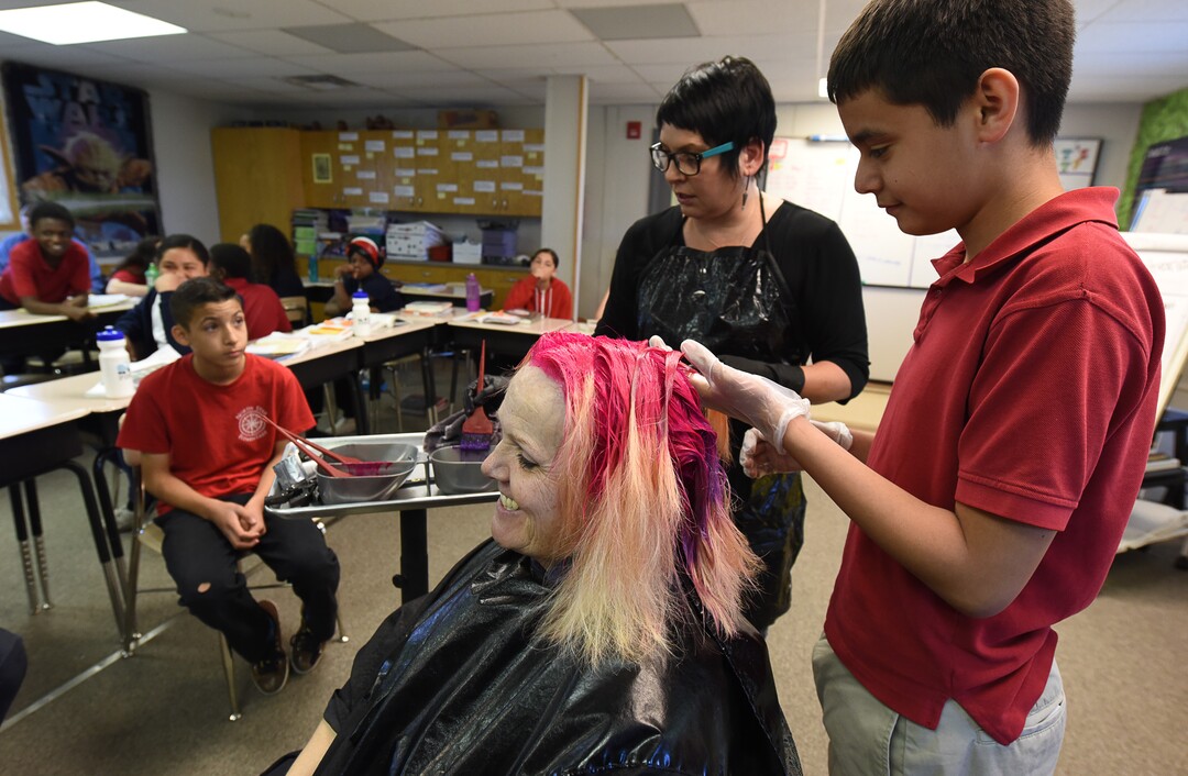 (Francisco Kjolseth  |  The Salt Lake Tribune)  Jonathan Soto, 12, gets a chance to put in some bright pink color into teacher Sharon Moore's hair after the 6th grade teacher at North Star Elementary agreed to the dye on Tuesday, May 8, 2018, after the students SAGE scores went up nearly 17 percent.