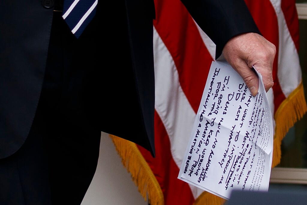 In this May 22, 2019, photo, President Donald Trump carries notes that say "they want to impeach me" as he walks from the Oval Office to speak in the Rose Garden of the White House in Washington. (AP Photo/Evan Vucci)
