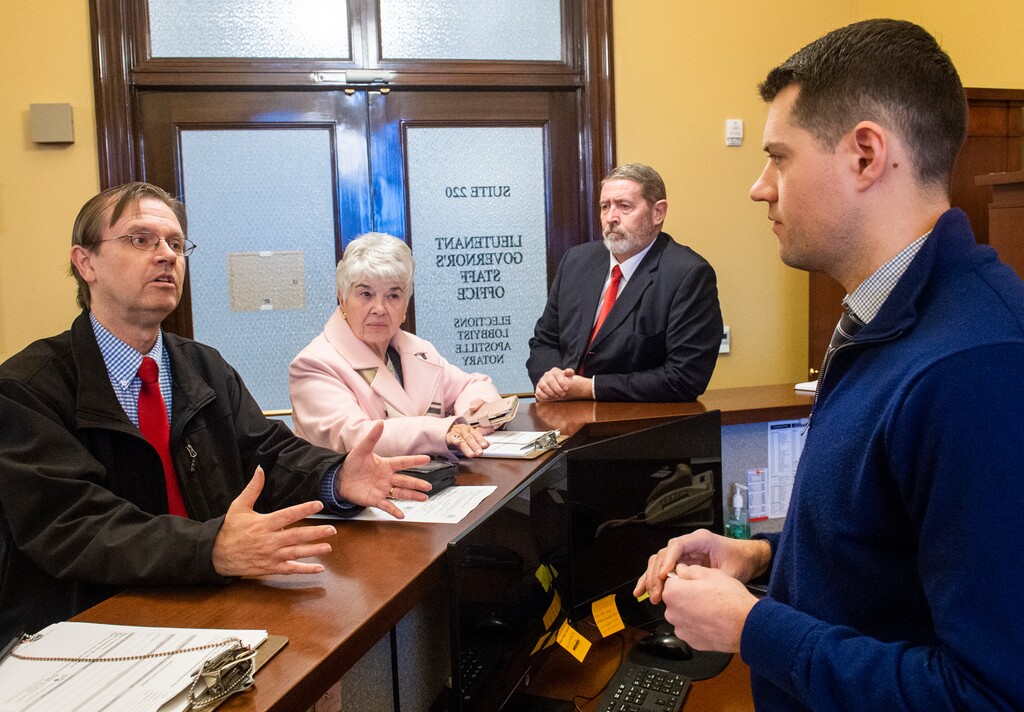 (Rick Egan  |  The Salt Lake Tribune) Former State Rep. Fred Cox, left, Judy Weeks Rohner and Matt Bell file paperwork with Special Assistant Seth Anderson to start signature gathering on an initiative seeking to allow voters to reject the newly-passed tax reform law on Monday, Dec. 16, 2019.