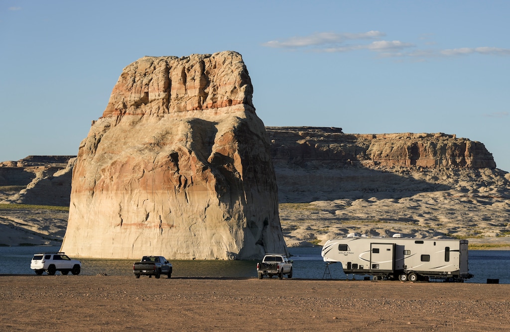 (Bethany Baker | The Salt Lake Tribune) Tourists gather at Lone Rock Beach near Page, Ariz. in 2023. After a recent settlement of two cases concerning off-road vehicle use in Glen Canyon National Recreation Area, the National Park Service must determine a specific lake elevation at which Lake Powell's shorelines, like at Lone Rock Beach, are open or closed to motorized vehicles.