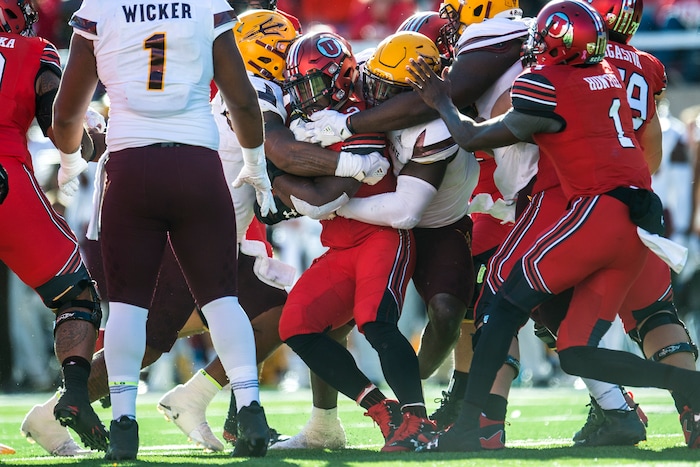 (Chris Detrick  |  The Salt Lake Tribune)  Utah Utes running back Zack Moss (2) is tackled by Arizona State Sun Devils defensive lineman Tashon Smallwood (90) and other Arizona State Sun Devils during the game at Rice-Eccles Stadium Saturday, October 21, 2017.  Arizona State Sun Devils defeated Utah Utes 30-10.