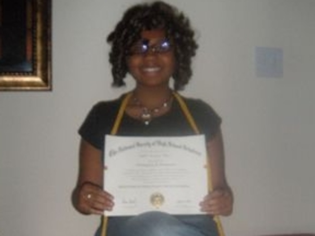 (Photo courtesy LaToya Mack) Cindreia Europe poses for a photo with her National Merit Scholar certificate.
