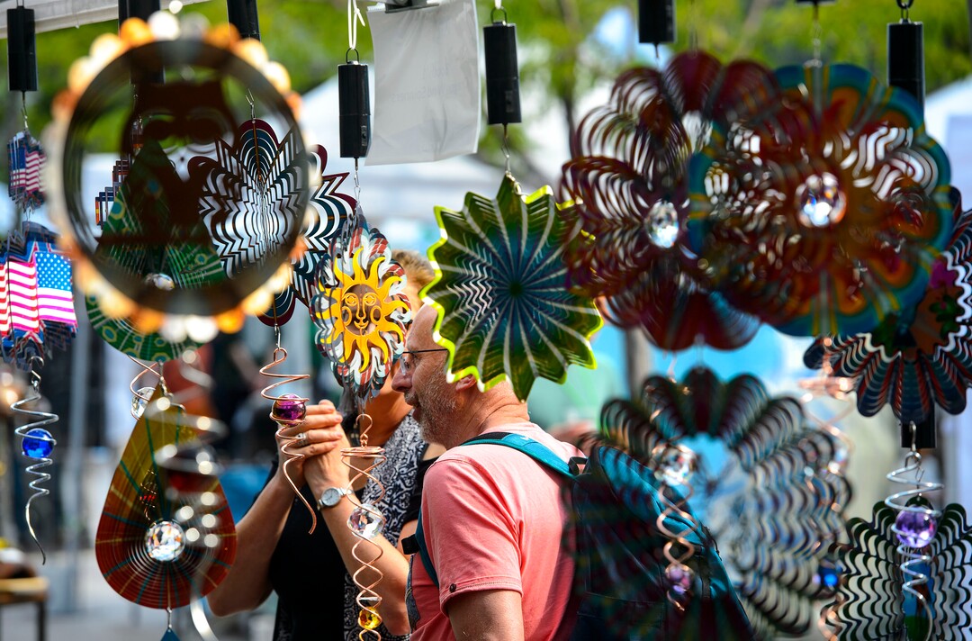 (Steve Griffin  |  The Salt Lake Tribune) People are fascinated by the Oregon Wind Spinners as the flash reflected light as they spin during the Urban Arts Festival at the Gallivan Center in Salt Lake City Sunday September 17, 2017. The two day festival featured artists, music, dance performance, automotive arts, projection art, virtual reality and new media arts.
