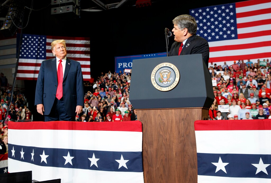(Carolyn Kaster | The Associated Press) President Donald Trump listens Fox News' Sean Hannity speak during a rally at Show Me Center, Monday, Nov. 5, 2018, in Cape Girardeau, Mo.