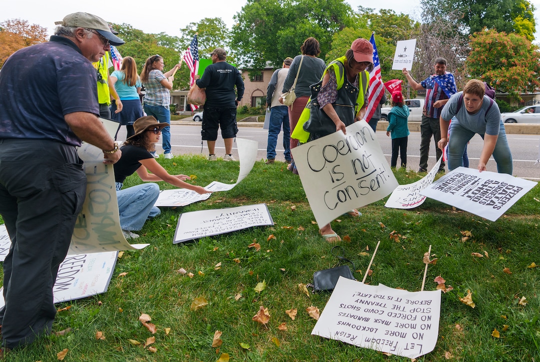 (Leah Hogsten | The Salt Lake Tribune) Protesters waving American flags and holding signs decrying mask and vaccine mandates gathered along the curb of 700 East in Liberty Park Saturday, making Salt Lake City one of dozens of cities around the world protesting public health-related restrictions, Sept. 18, 2021.