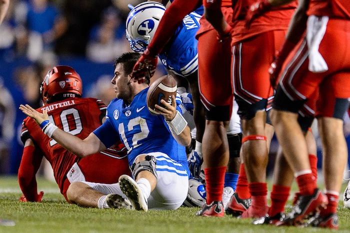 (Trent Nelson | The Salt Lake Tribune)  Brigham Young Cougars quarterback Tanner Mangum (12) looks for a call and gets it after he's apparently hit while sliding, as BYU hosts Utah, NCAA football in Provo, Saturday September 9, 2017.