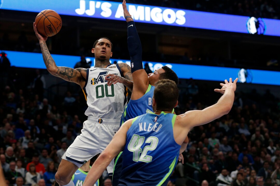 Utah Jazz guard Jordan Clarkson (00) passes the ball as he is defended by Dallas Mavericks guard Jalen Brunson (13) and forward Maxi Kleber (42) during the second half an NBA basketball game in Dallas, Monday, Feb. 10, 2020. Utah defeated Dallas 123-119. (AP Photo/Michael Ainsworth)