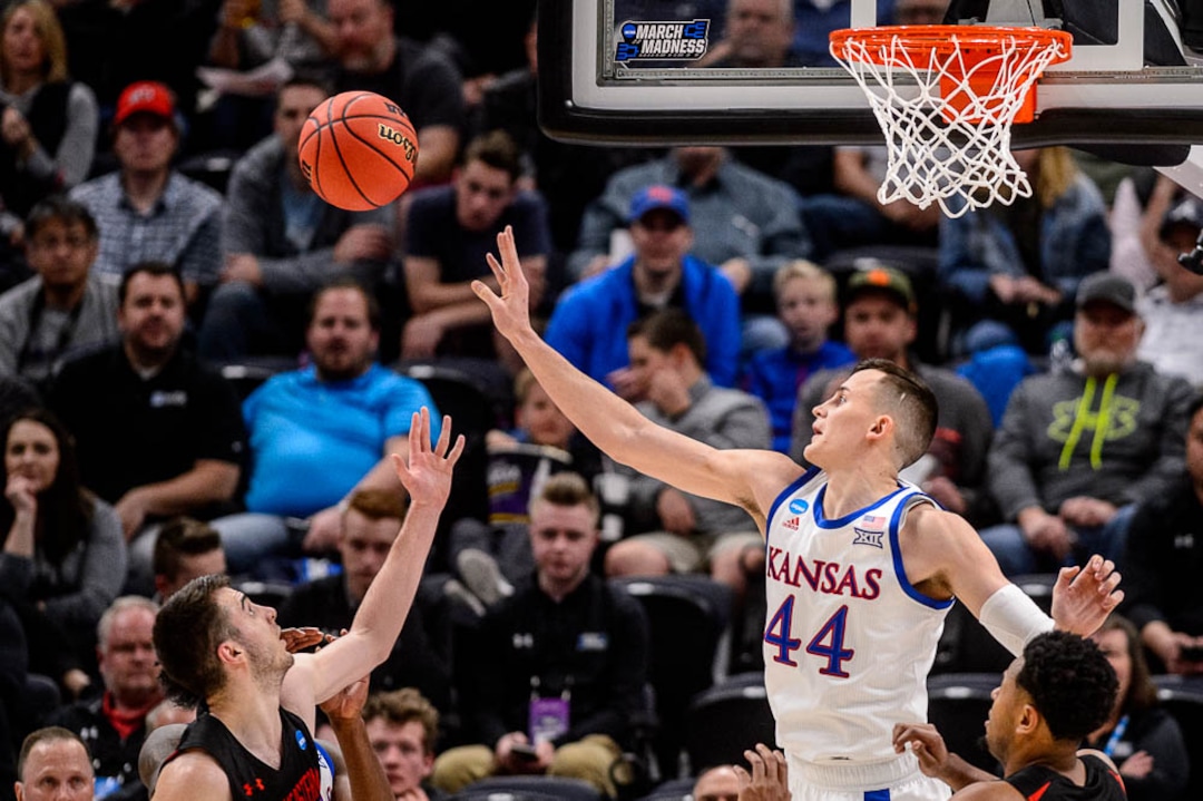 (Trent Nelson | The Salt Lake Tribune)  Kansas Jayhawks forward Mitch Lightfoot (44) blocks a shot by Northeastern Huskies guard Vasa Pusica (4) as Kansas faces Northeastern in the 2019 NCAA Tournament in Salt Lake City on Thursday March 21, 2019.