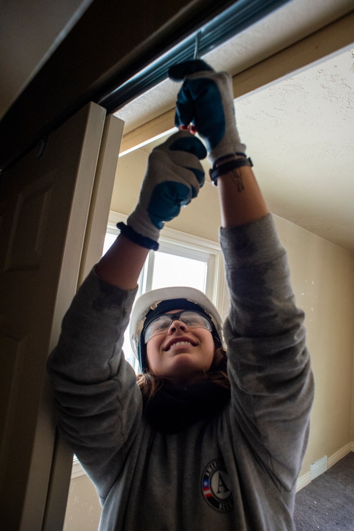 (Rick Egan  |  The Salt Lake Tribune)       Abby Chiesa removes a closet door from a home that will be demolished for freeway widening, for UDOT and Habitat for Humanity, Wednesday, Jan. 16, 2019.





