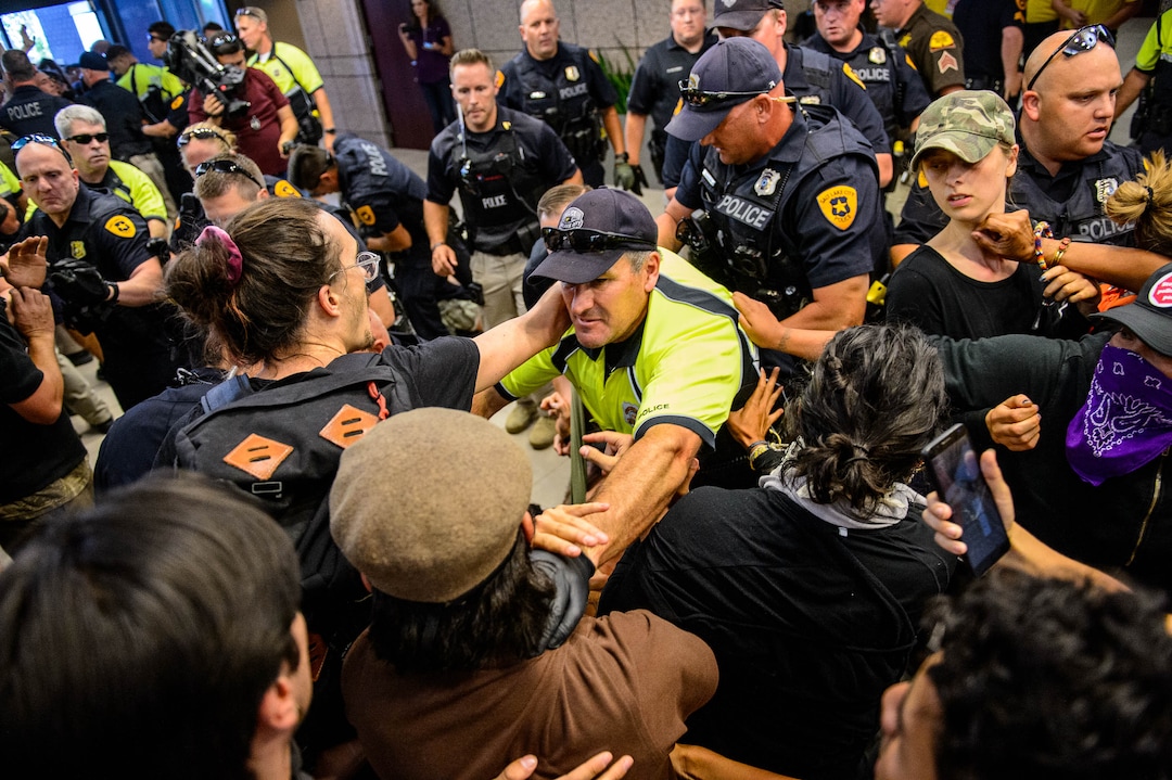 (Trent Nelson  |  The Salt Lake Tribune) Police remove protesters occupying the Chamber of Commerce Building Salt Lake City on Tuesday, July 9, 2019. Dozens of people showed up to protest the planned Inland Port. The protest began at City Hall and moved to the Chamber of Commerce.