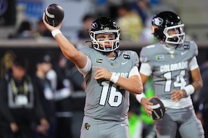 Colorado quarterbacks Isaac Wilson, front, and Kaneal Sweetwyne warm up before an NCAA college football game against Utah Saturday, Oct. 17 2026, in Boulder, Colo. (AP Photo/David Zalubowski)