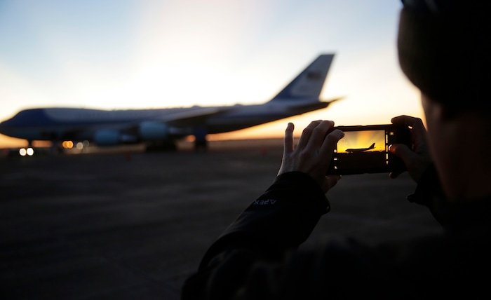 A member of the military takes a photo as the sun rises behind Special Air Mission 41, the plane that will transfer the casket of former President George H.W. Bush to Washington, Monday, Dec. 3, 2018, in Houston. Bush, died late Friday at his Houston home at age 94, is to be honored with a state funeral at National Cathedral in the nation's capital on Wednesday, followed by burial Thursday on the grounds of his presidential library at Texas A&M. (AP Photo/Eric Gay)