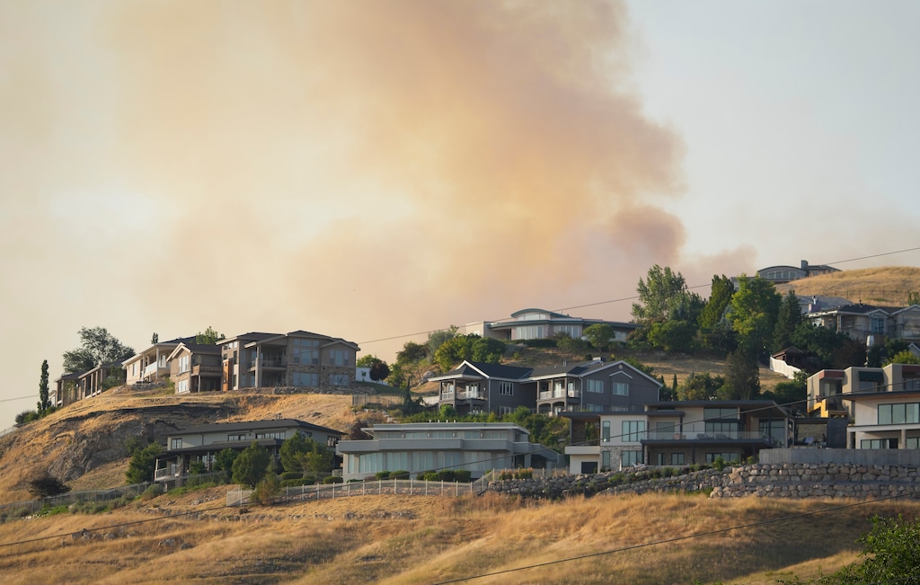 (Bethany Baker  |  The Salt Lake Tribune) Smoke rises up behind homes near the Sandhurst Fire in Salt Lake City on July 20, 2024.