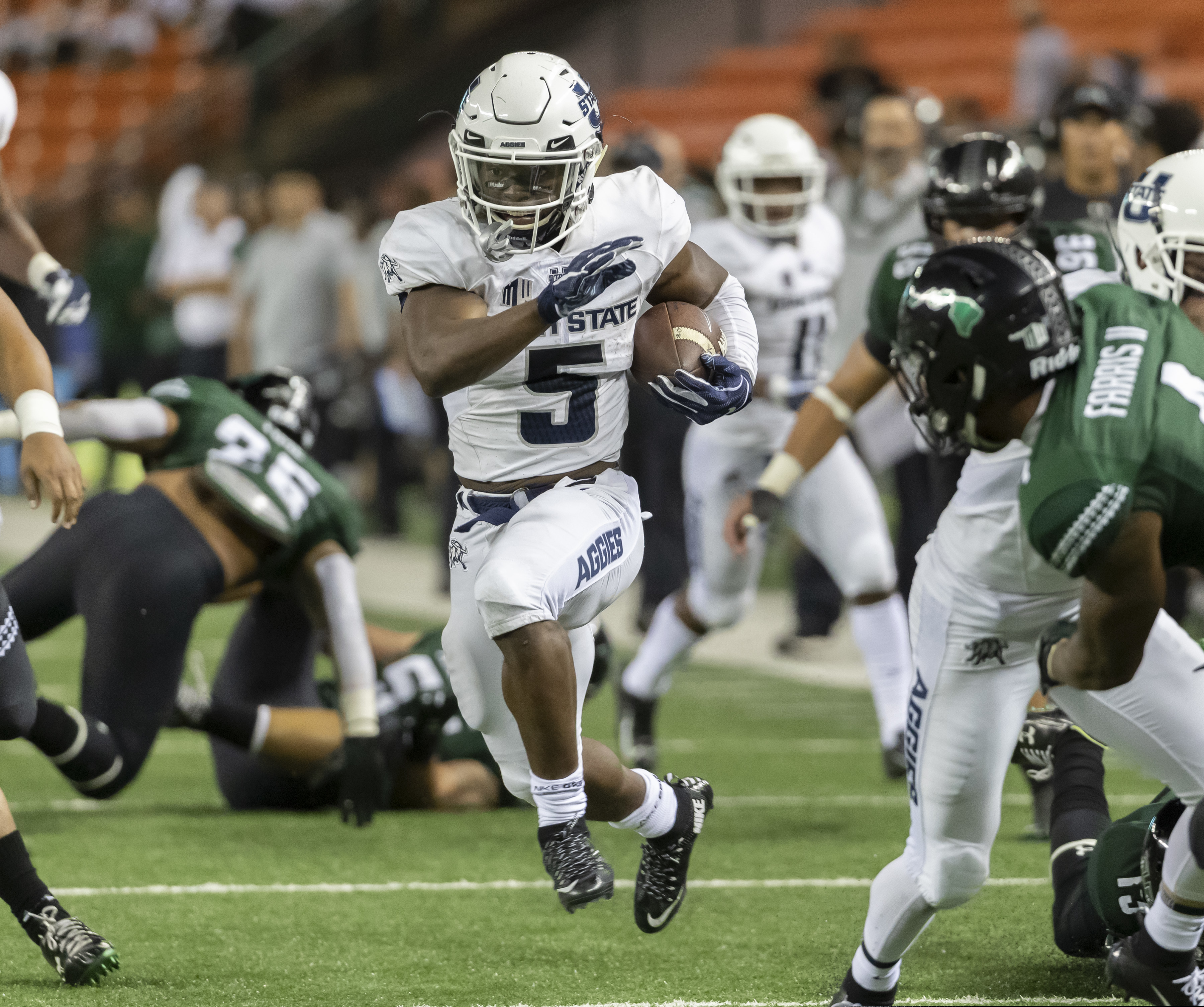 Utah State running back Darwin Thompson (5) shoots through an opening in the Hawaii defense and runs in for a touchdown in the second half of an NCAA college football game, Saturday, Nov. 3, 2018, in Honolulu. (AP Photo/Eugene Tanner)