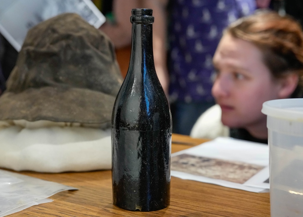 (Francisco Kjolseth  | The Salt Lake Tribune) A more than 150-year-old leather miners hat and bottle of alcohol draws attention after being recently discovered during an archaeological dig in the town of Alta, Friday, Jan. 9, 2026. High West Distillery with the help of Uinta Brewing Co., is in the process of analyzing the contents for reproduction. 