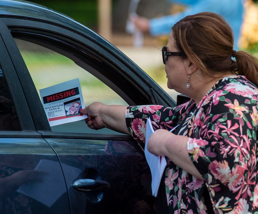 (Rick Egan  |  The Salt Lake Tribune)  In this Saturday, June 22, 2019 photo, Sara Richardson hands a motorists a sign with MacKenzie Lueck's photo in Liberty Park in Salt Lake City.