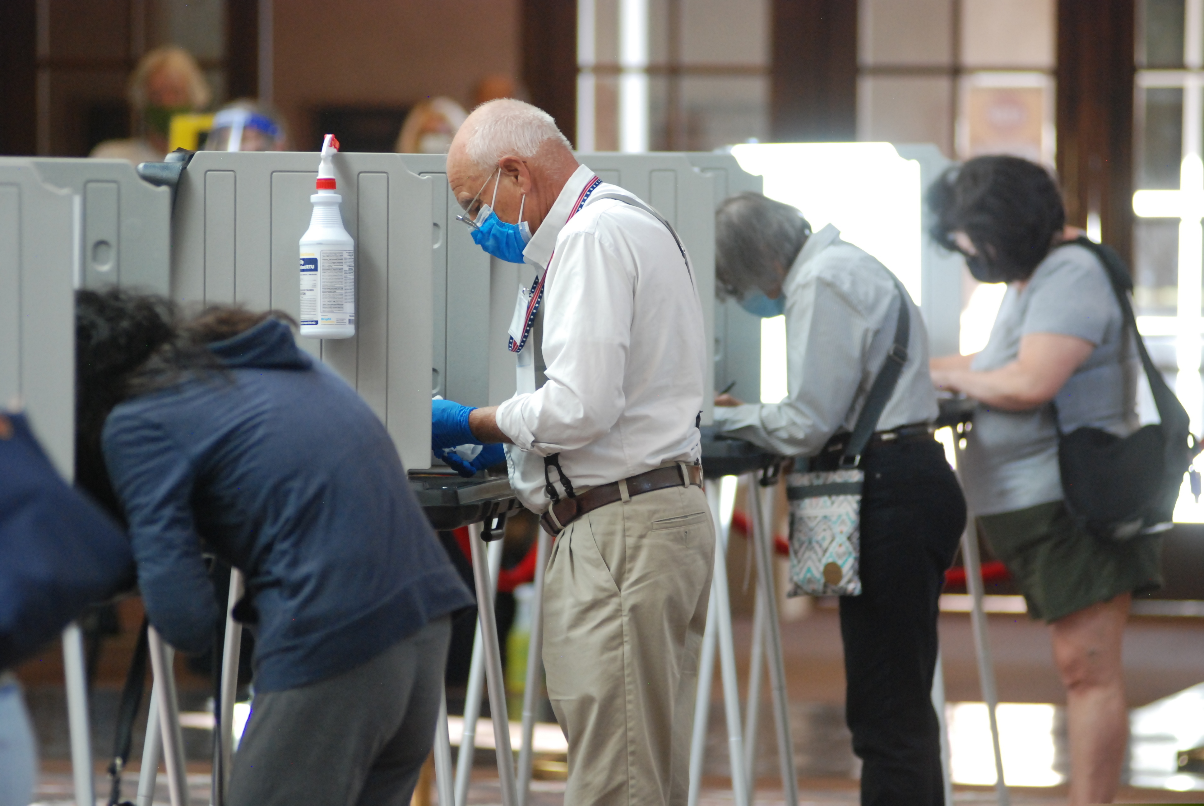 (Morgan Lee | AP file photo)  A temporary election worker disinfects voting stations as a precaution against the coronavirus while a steady stream of voters participates in the first day of balloting in New Mexico, at the Santa Fe Convention Center on Tuesday, Oct. 6, 2020, in Santa Fe, N.M.