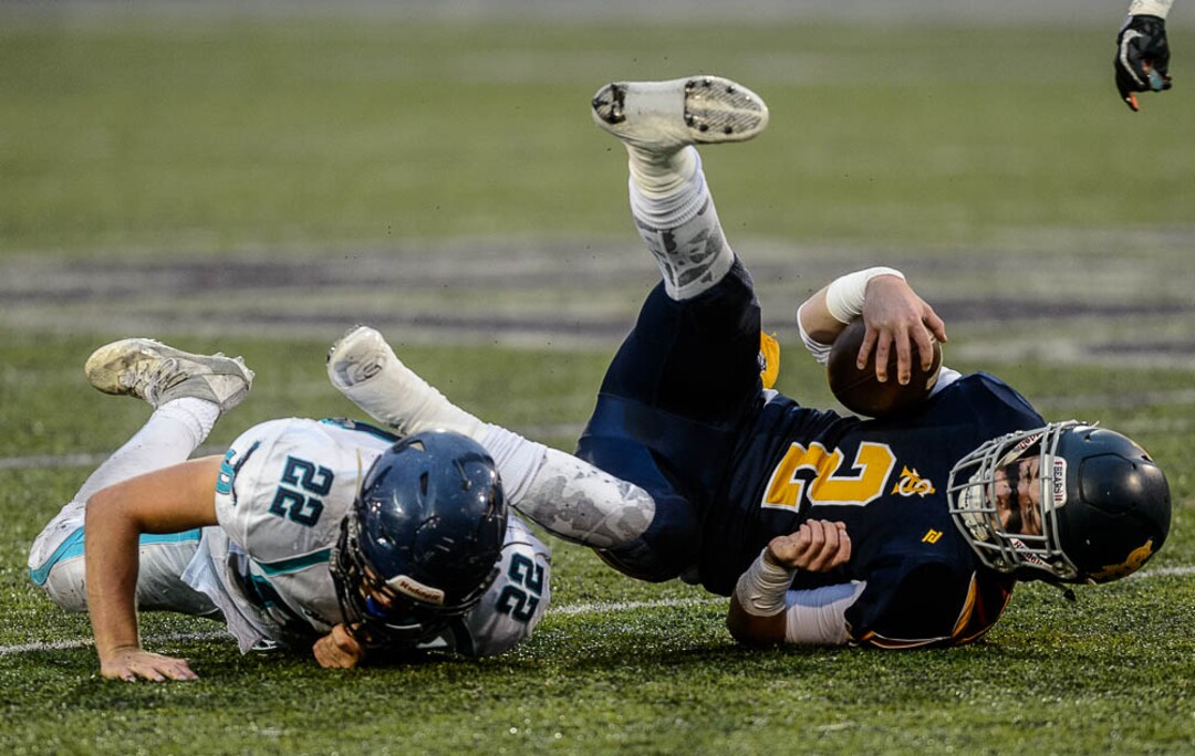 (Trent Nelson | The Salt Lake Tribune)  Summit Academy quarterback Haden Reynolds is brought down by Juan Diego's Tristen Tonozzi. Summit Academy faces Juan Diego High School in a class 3A state semifinal football game at Weber State University's Stewart Stadium, Saturday November 4, 2017.