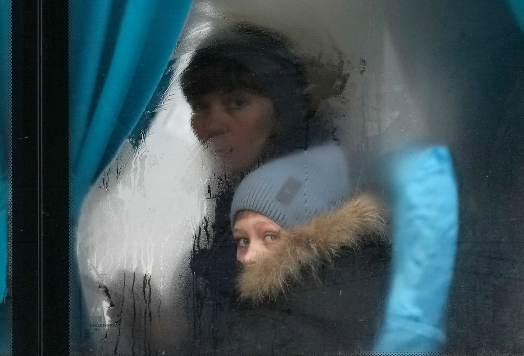 (Vadim Ghirda | AP) A woman and child peer out of the window of a bus as they leave Sievierodonetsk, the Luhansk region, eastern Ukraine, Thursday, Feb. 24, 2022.