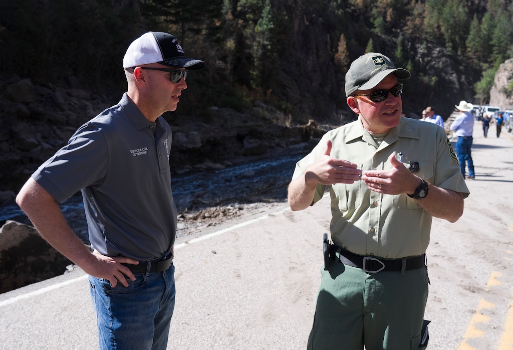 (Bethany Baker  |  The Salt Lake Tribune) Gov. Spencer Cox, left, listens as U.S. Forest Service Chief Tom Schultz speaks about recovery efforts in the burn scar of the Cottonwood Fire near Beaver on Thursday, Aug. 6, 2026.