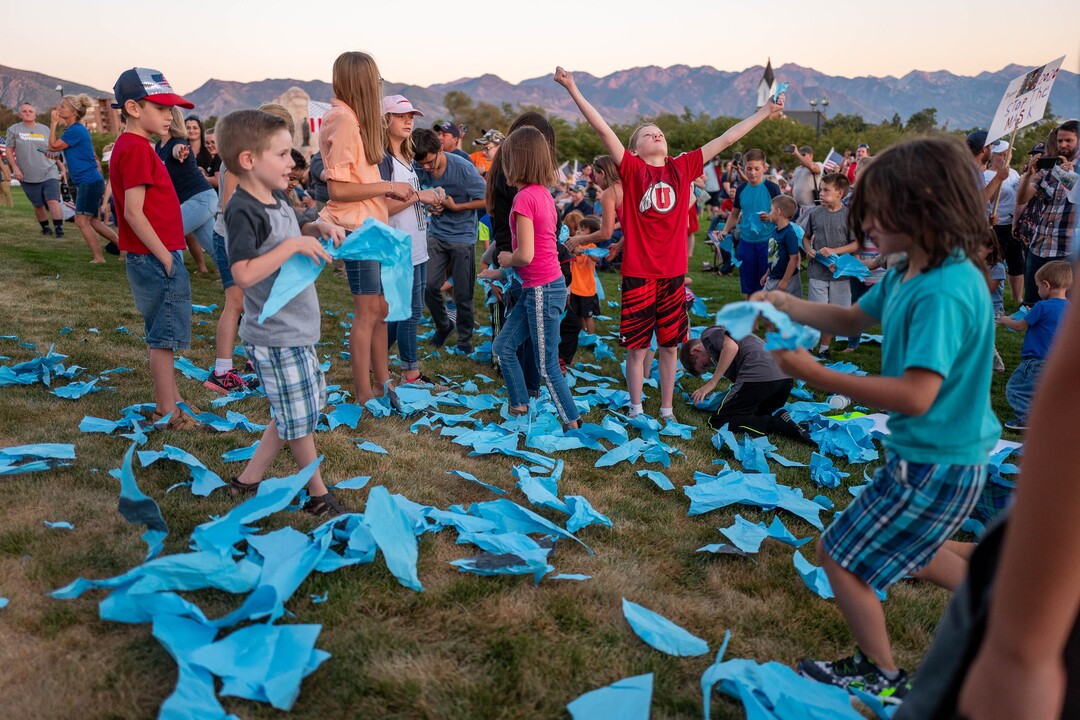 (Trent Nelson  |  The Salt Lake Tribune) Children rip up a large paper mask at a rally protesting government mask mandates at the State Capitol in Salt Lake City on Saturday, Sept. 5, 2020.