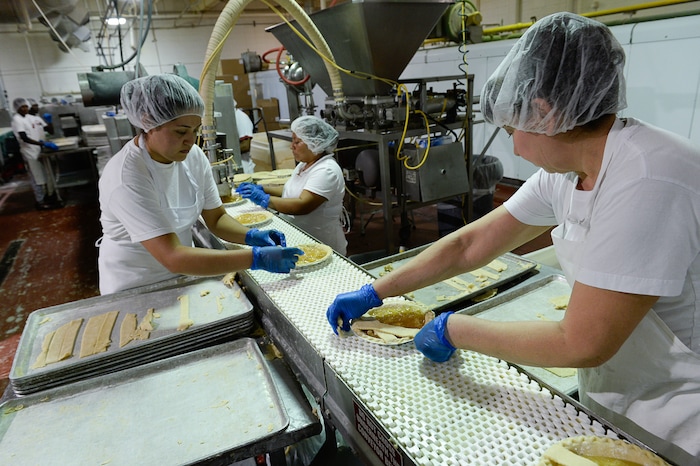 Francisco Kjolseth | The Salt Lake Tribune
Workers assemble hand laid lattice apple pie at Rocky Mountain Pie factory in Salt Lake recently. Eight different pies sold through Associated Food Stores earned blue ribbons in the commercial categories at the National Pie Championships.