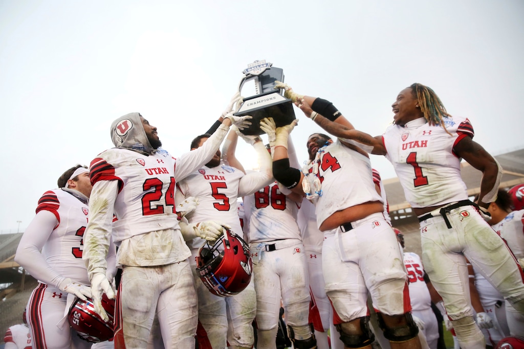 Utah football players hold up their championship trophy after winning the Zaxby's Heart of Dallas Bowl against West Virginia at Cotton Bowl Stadium in Dallas on Wednesday, Dec. 26, 2017. Utah won 30-14. (Rose Baca/The Dallas Morning News via AP)