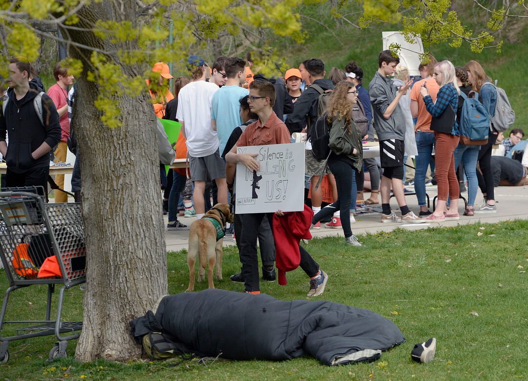 (Al Hartmann  |  The Salt Lake Tribune) 	Homeless man tries to sleep in his sleeping bag at Sugarouse Park where over one hundred students at Highland High School staged a walkout Friday April 20, 2018 in honor of the anniversary of the Columbine High School massacre. Demonstrators walked from the school to Sugar House Park where they made posters, wrote letters to their congressmen and listened to speakers. 