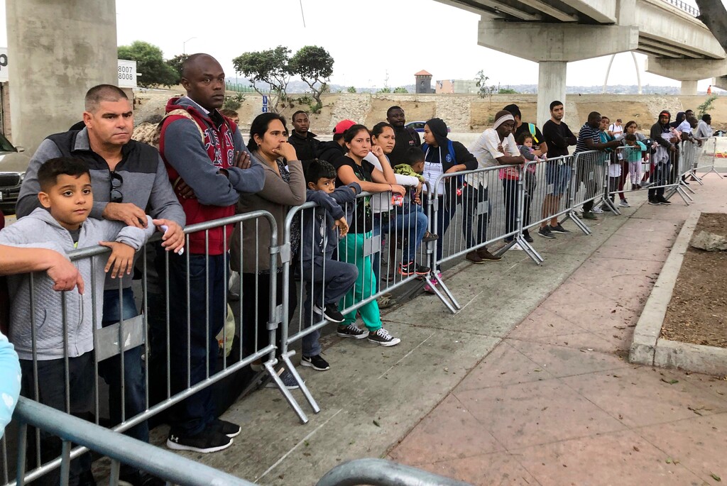 (Elliot Spagat | AP file photo) Asylum seekers, in Tijuana, Mexico, listen to names being called from a waiting list to claim asylum at a border crossing in San Diego on Sept. 26, 2019.