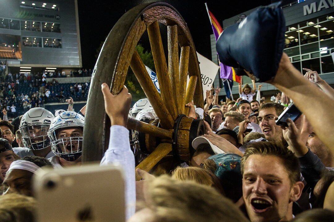 (Chris Detrick  |  The Salt Lake Tribune)  Utah State Aggies  football players and students celebrate with the Old Wagon Wheel after the game at Merlin Olsen Field at Maverik Stadium Friday, September 29, 2017. Utah State Aggies defeated Brigham Young Cougars 40-24.