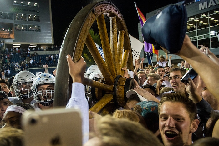 (Chris Detrick  |  The Salt Lake Tribune)  Utah State Aggies  football players and students celebrate with the Old Wagon Wheel after the game at Merlin Olsen Field at Maverik Stadium Friday, September 29, 2017. Utah State Aggies defeated Brigham Young Cougars 40-24.