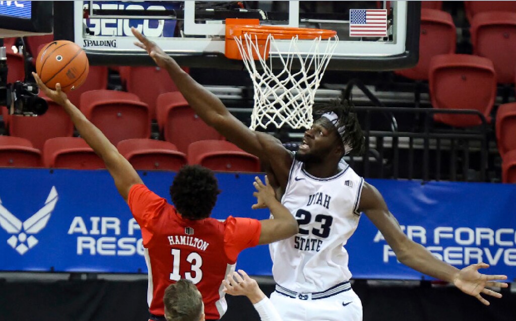 UNLV guard Bryce Hamilton (13) shoots as Utah State center Neemias Queta (23) defends during the first half of an NCAA college basketball game in the quarterfinals of the Mountain West Conference men's tournament Thursday, March 11, 2021, in Las Vegas. (AP Photo/Isaac Brekken)