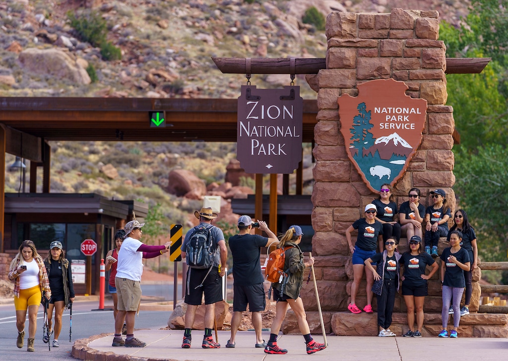 (Leah Hogsten | The Salt Lake Tribune) Zion National Park visitors take pictures at the iconic park entrance sign, Sept. 26, 2021. 