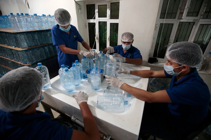 In this photo taken on Saturday, Jul. 8, 2017, workers fill bottles with water at the mineral water refilling station in Sanaa, Yemen. Yemen’s raging two-year conflict has served as an incubator for lethal cholera. (AP Photo/Hani Mohammed)