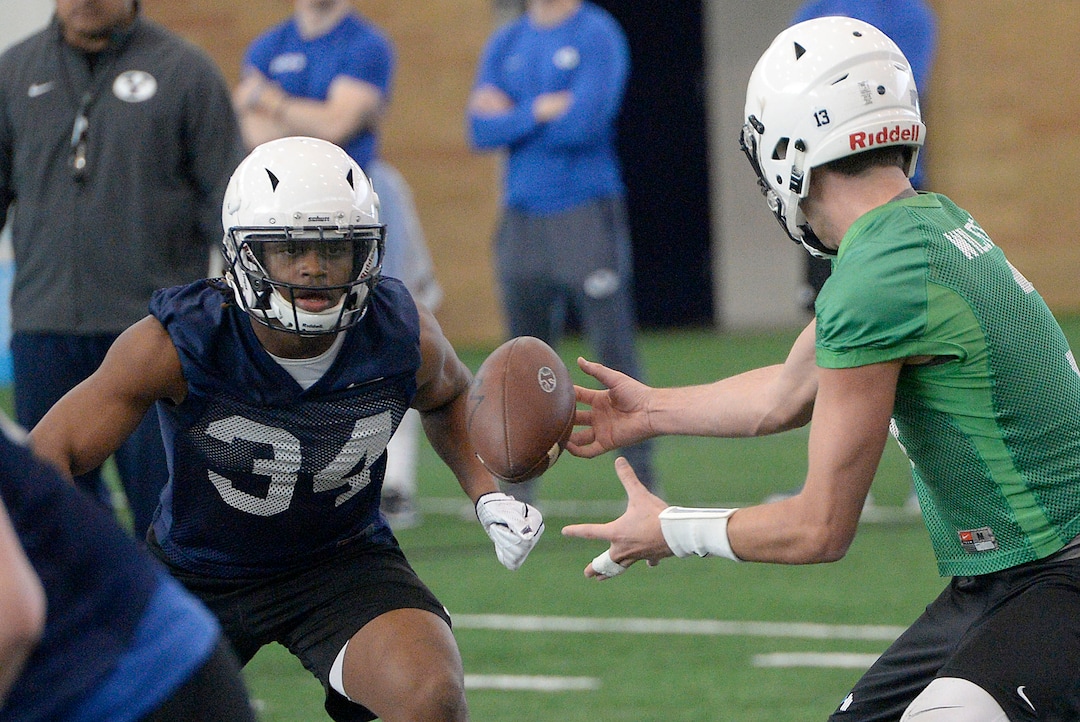 (Al Hartmann  |  The Salt Lake Tribune) 	 BYU opened spring football camp on Monday March 5 in the indoor playing facility. Quarterback Kody Wilstead, left, hands off to running back Riley Burt. 