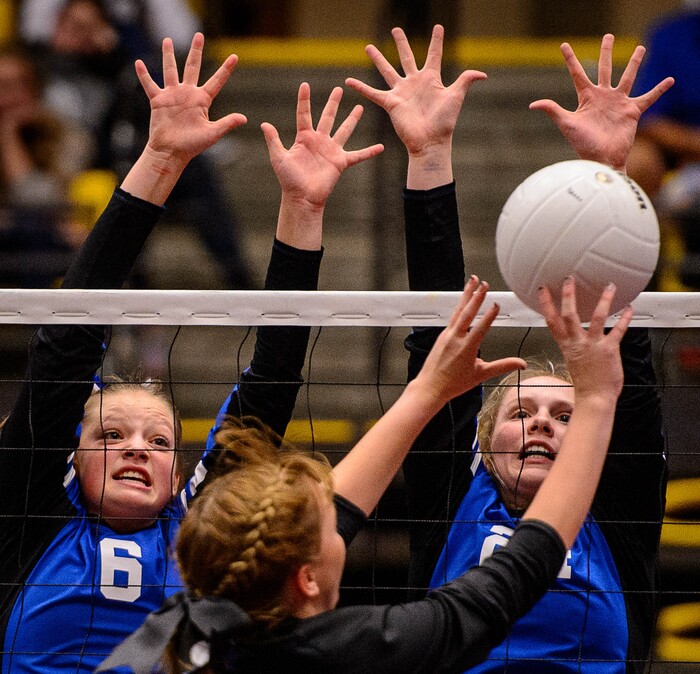 (Trent Nelson | The Salt Lake Tribune) Panguitch's Kiesa Miller and Panguitch's Abbey Blevins leap up while Rich's Savannah Peart hits the ball as Panguitch defeats Rich in the 1A State Volleyball Championship game in Orem, Saturday October 28, 2017.
