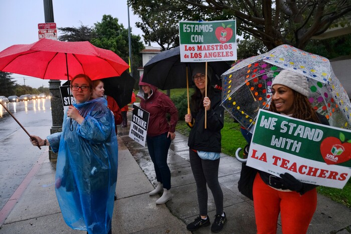 (Richard Vogel | The Associated Press)  Teacher Sheila Reid, right, braves the rain with her colleagues during a city-wide teacher strike at Los Angeles High School on Monday, Jan. 14, 2019. Tens of thousands of Los Angeles teachers went on strike Monday after contentious contract negotiations failed in the nation's second-largest school district.