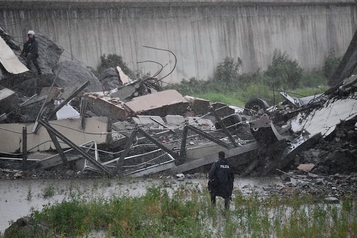 Rescues work among the debris of the collapsed Morandi highway bridge in Genoa, Tuesday, Aug. 14, 2018. Italian authorities say that about 10 vehicles were involved when the raised highway collapsed during a sudden and violent storm in the northern port city of Genoa, while private broadcaster Sky TG24 said the collapsed section was about 200-meter long (650 feet). (Luca Zennaro/ANSA via AP)