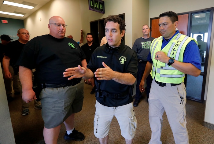 (Tony Gutierrez | AP Photo) In this July 21, 2019 photo, Brian Ovens, left, looks on as Bryan Hetherington, center, ask a question of police officer and instructor Nick Guadarrama, right, during a security training session at Fellowship of the Parks campus in Haslet, Texas.  While recent mass shootings occurred at a retail store in El Paso, Texas, and a downtown entertainment district in Dayton, Ohio, they were still felt in houses of worship, which haven’t been immune to such attacks. And some churches have started protecting themselves with guns.